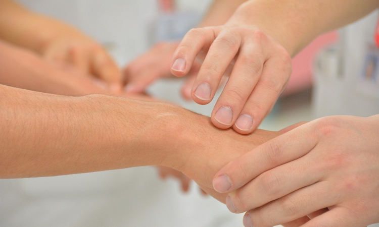 Health professional taking patient's pulse